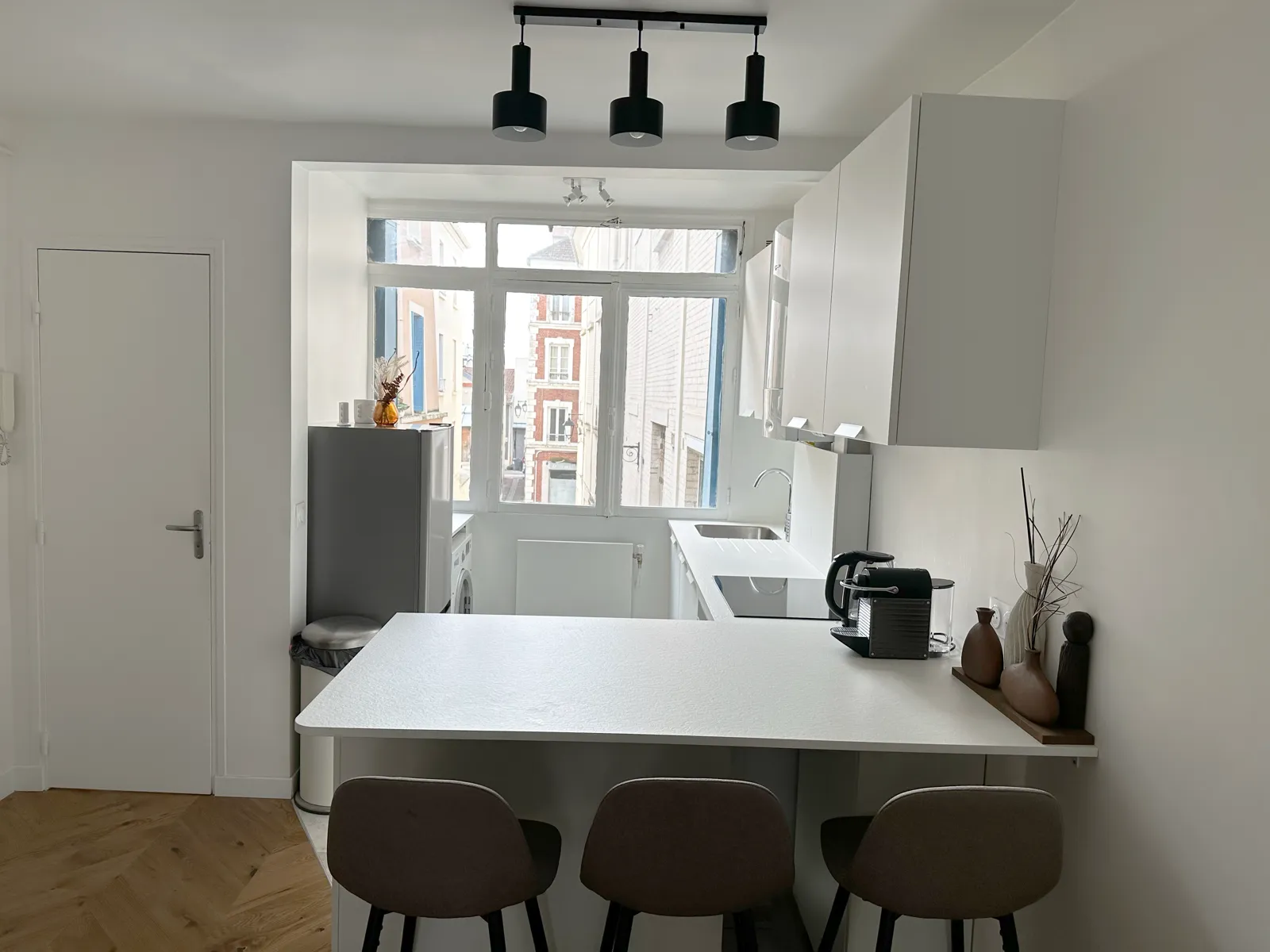 Cuisine équipée avec bar et tabourets — hébergement Saint-Germain-en-Laye