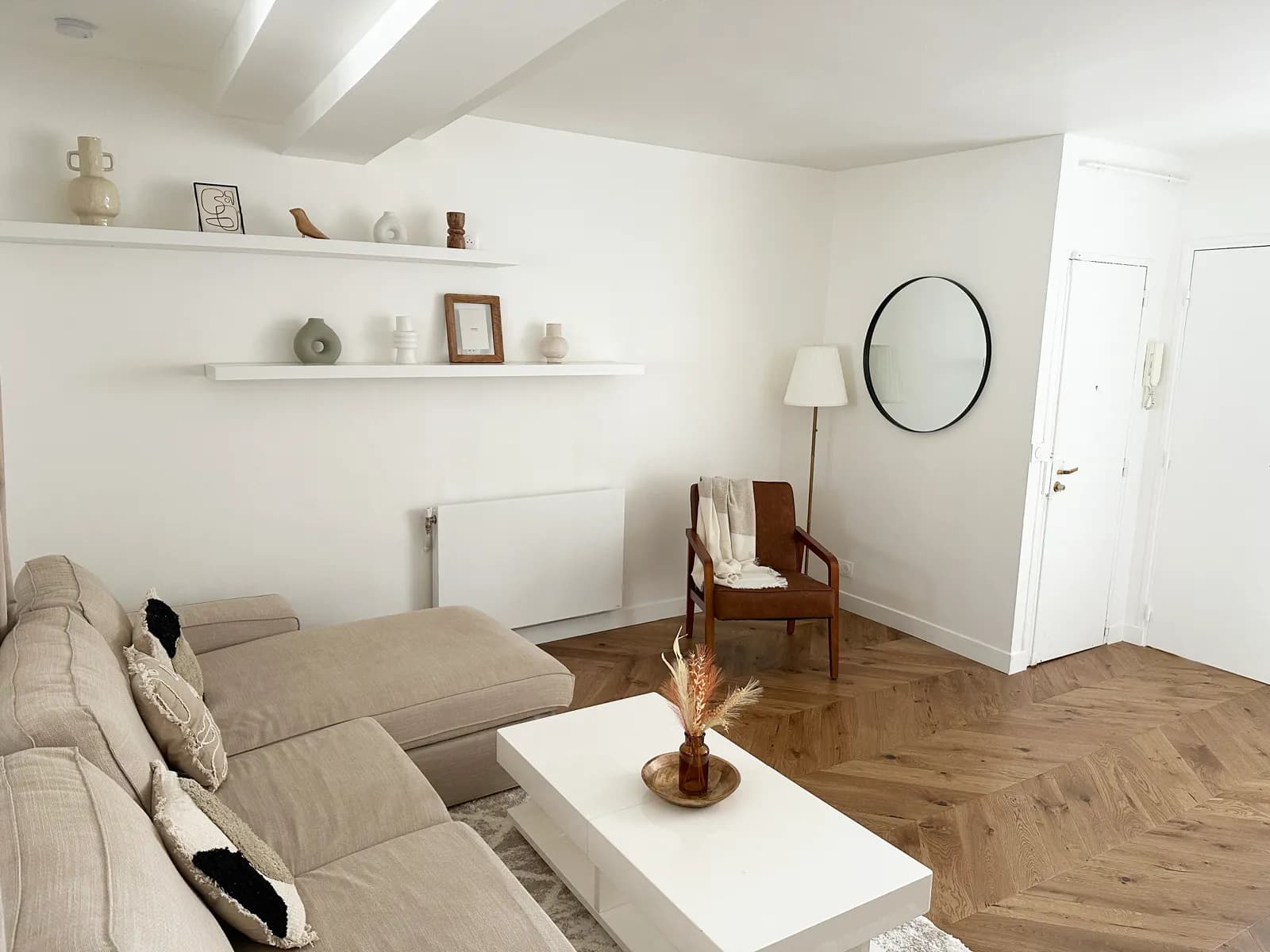 Salon avec canapé d'angle et étagères décoratives — appartement centre-ville Saint-Germain-en-Laye